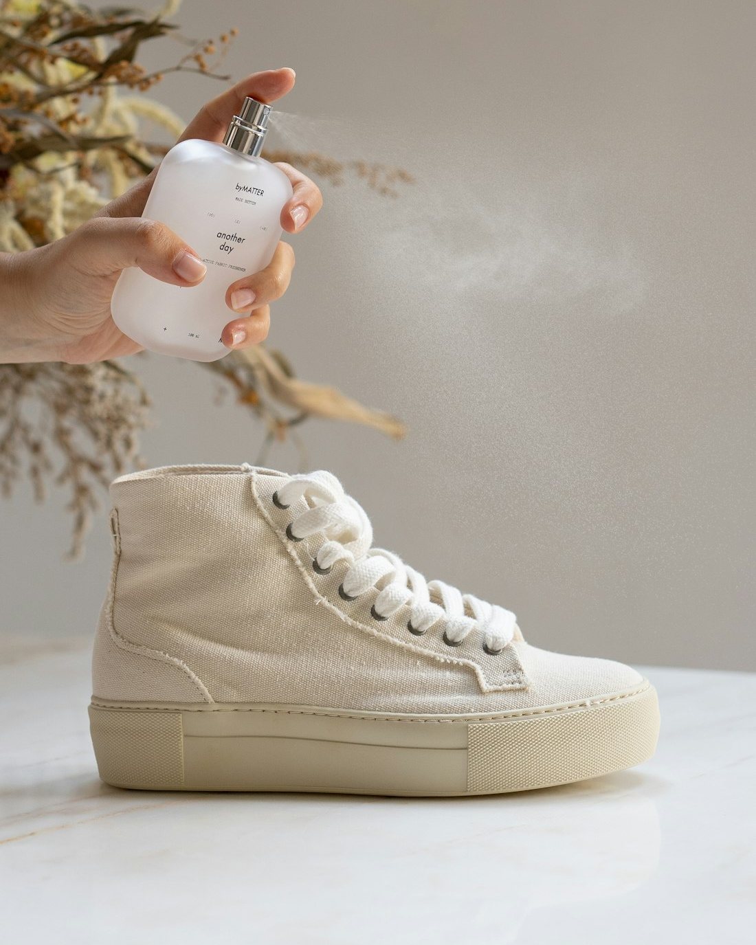Perawatan sneaker kanvas dengan semprotan pembersih di workshop Flaz Shoe Care